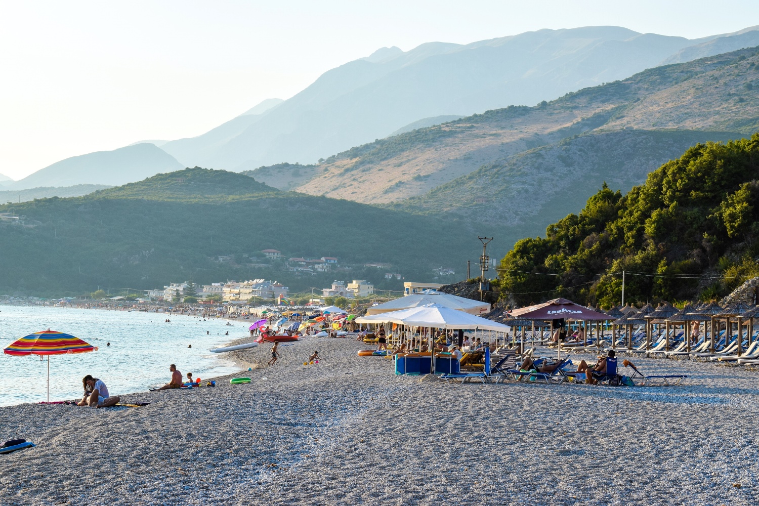 Livadhi Beach in Himara — smooth pebbles, clear Ionian water and mountain backdrop