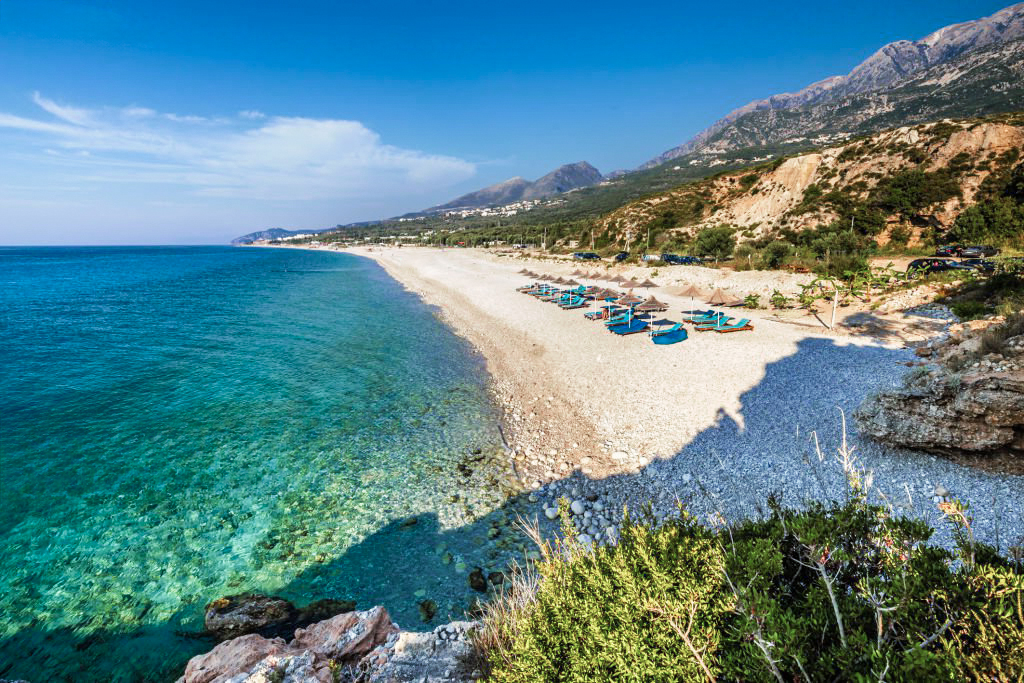 Dhermi Beach — long crescent of white pebbles backed by green mountains on the Albanian Riviera