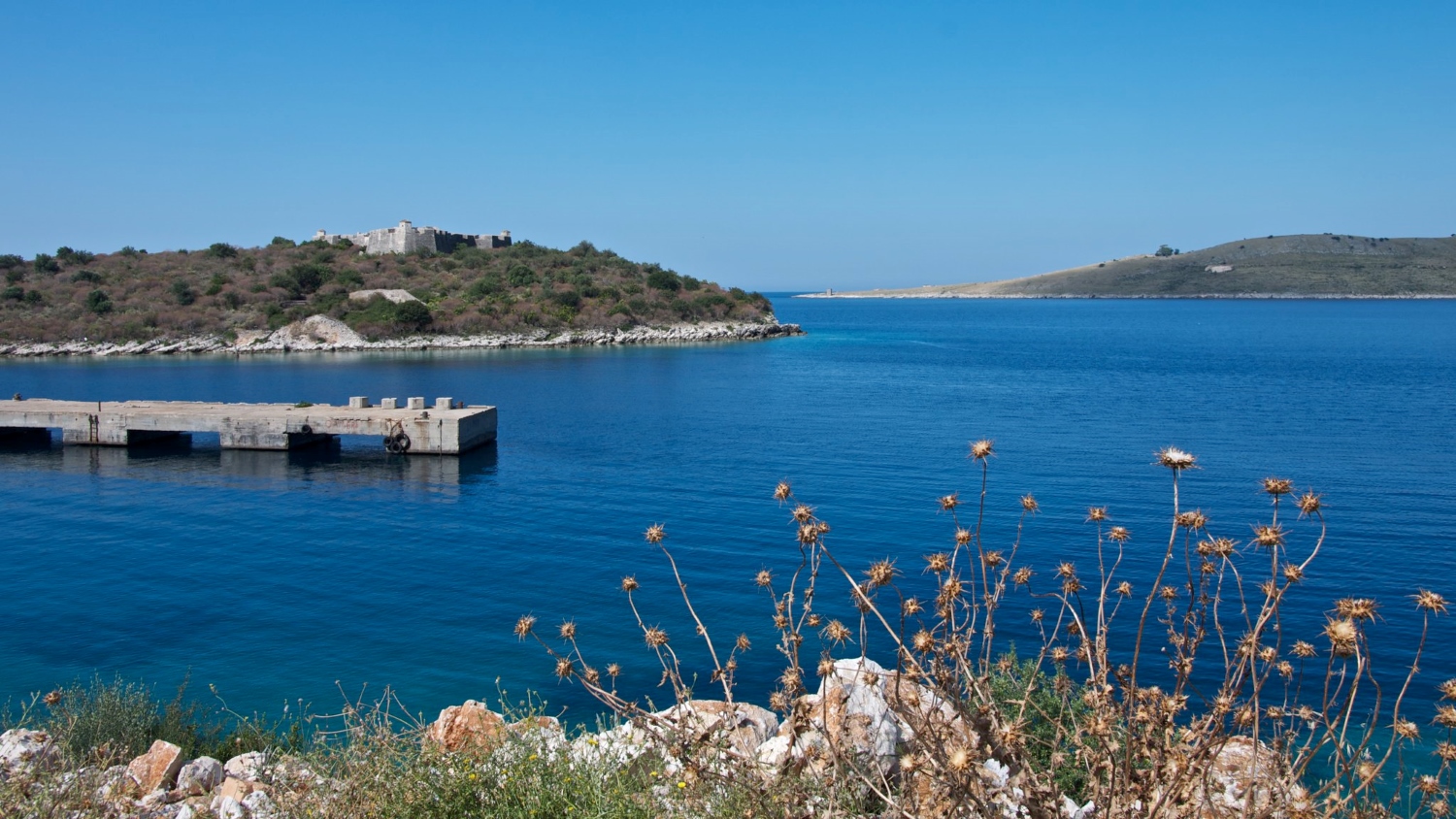 Porto Palermo Albania — view across the sheltered bay toward the castle and mountain backdrop