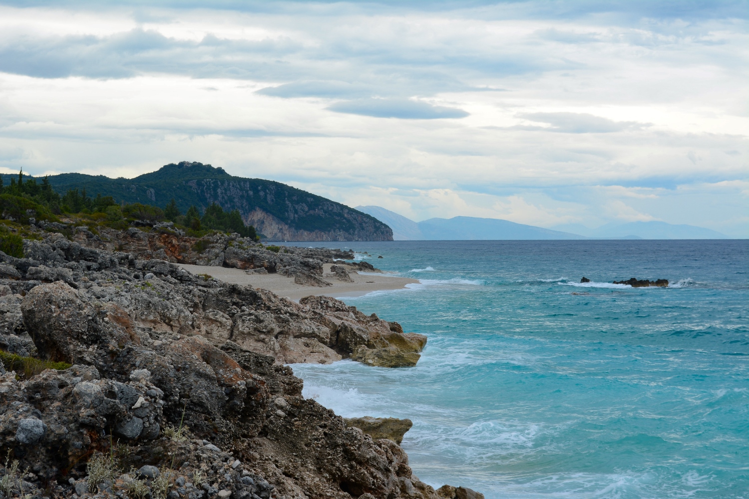 Drymades Beach Albania — aerial view of the pebble cove with turquoise Ionian water