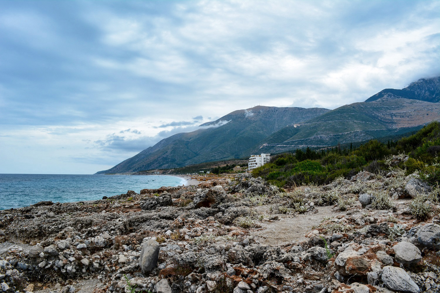 Drymades Beach Albania — beach clubs and swimmers in clear Ionian water