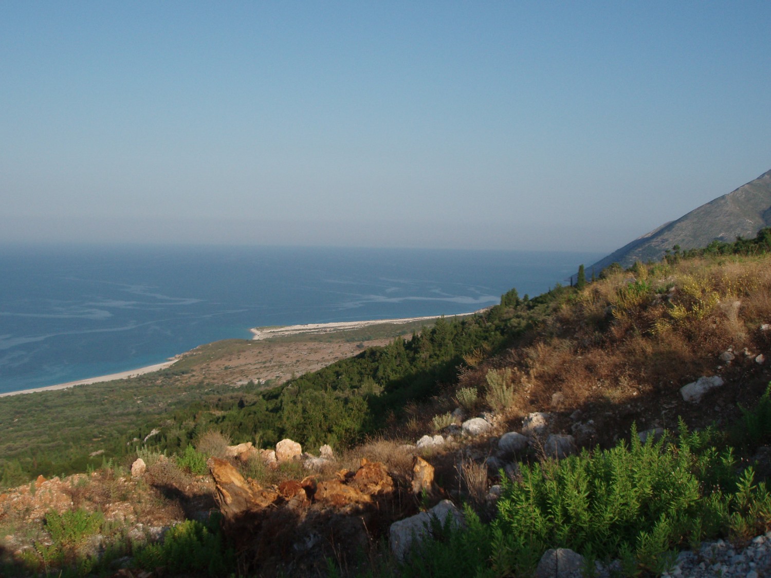Drymades Beach Albania — white pebble cove with deep blue Ionian water and Ceraunian Mountains backdrop