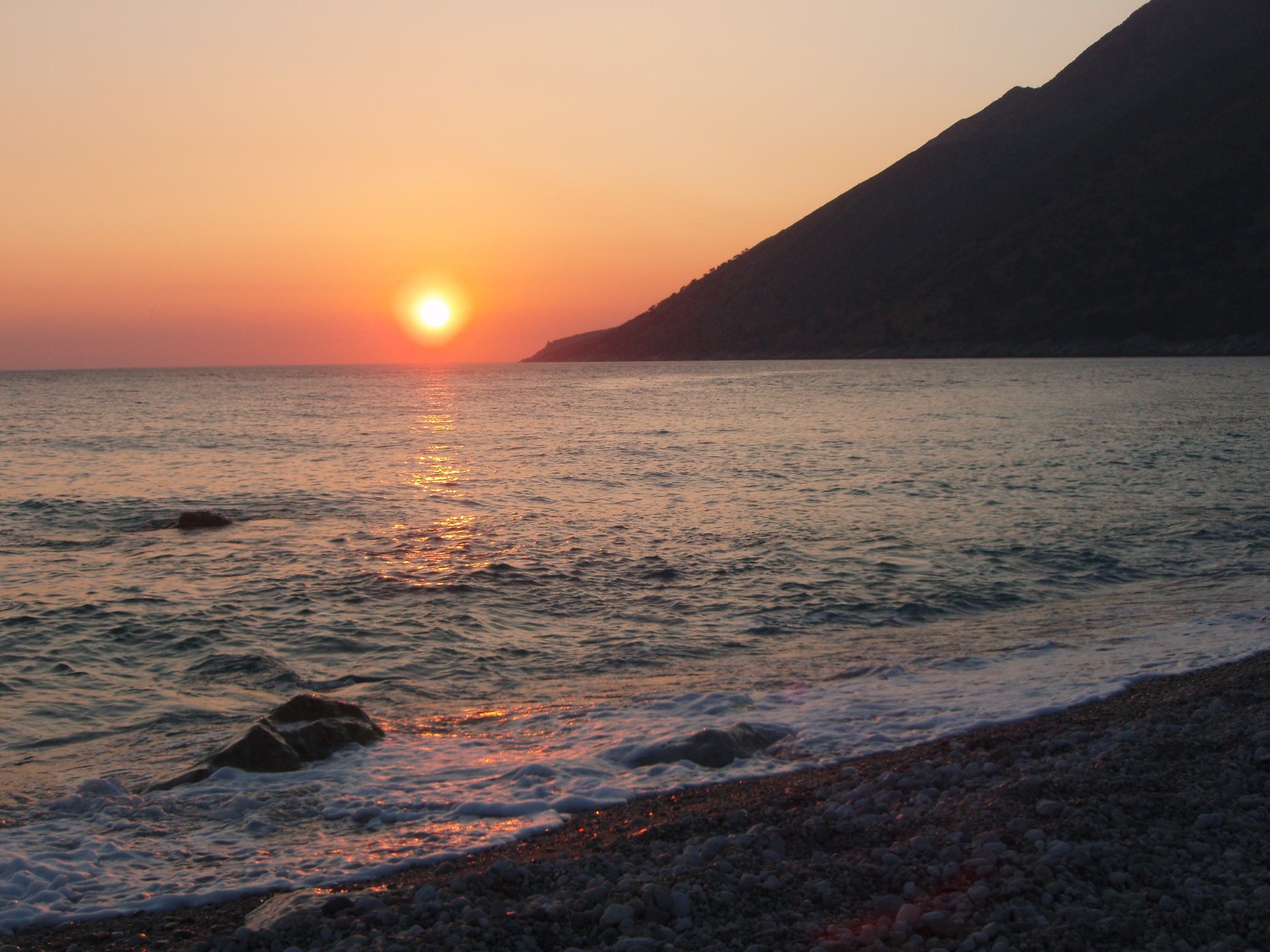 Drymades Beach Albania — view from above showing the white pebble cove and mountain-sea setting